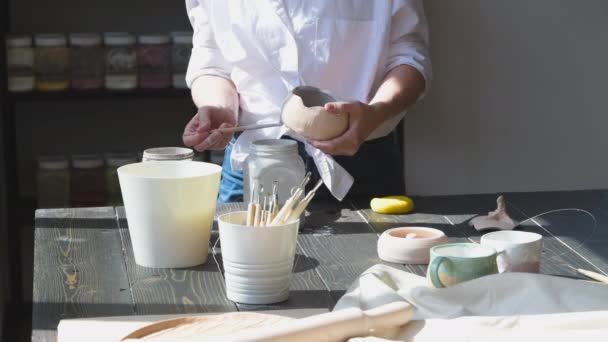 Zbliżenie kobiety wykonującej ceramiczne i ceramiczne zastawy stołowe w warsztacie, pracującej z gliny i glazury. — Wideo stockowe