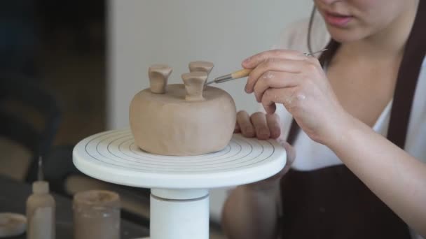 Close up de mãos femininas segurando vara e fazendo ornamento em faiança. Argila mestre produto de moldagem de argila. Conceito de arte cerâmica e hobby . — Vídeo de Stock