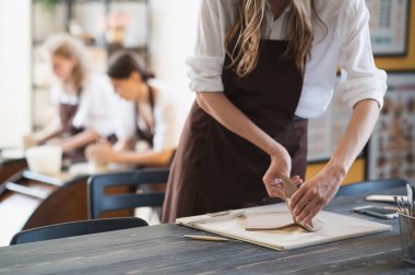 Esnaf kadın çömlekçi çömlekleri için malzeme hazırlıyor. Kadın elleri gelecekteki seramik ürünlere kilden parçalar ekliyor. Yakın plan çalış..