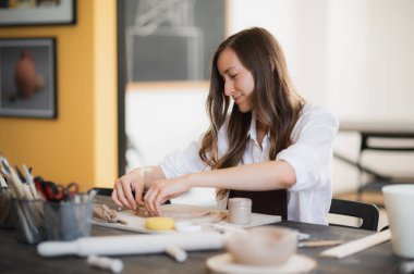 Çömlekçilik atölyesinde seramik ürün yaparken kilden bir parça alan yetenekli ustabaşının kapanışı
