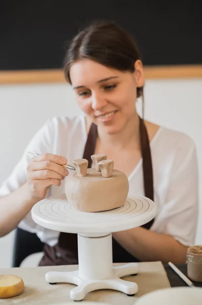 スティックを保持し、装飾品に飾りを作る女性の手。陶磁器工房の土師型粘土. — ストック写真