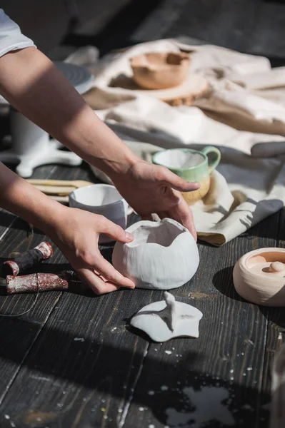 Female potter making ceramic dishes at her studio. Working process of glazing ceramic bowl. — Stock Photo, Image