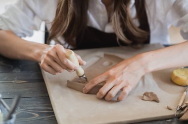 Çömlekçilik atölyesinde seramik ürün yaparken kilden bir parça alan yetenekli ustabaşının kapanışı