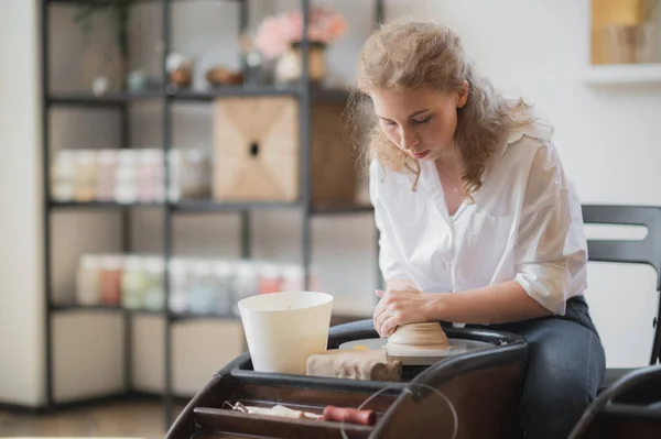 Close-up van de vrouw handen werken op aardewerk wiel en het maken van klei pot. Handen beeldhouwt een kopje uit klei pot. Workshop over modellering op het pottenbakkerswiel — Stockfoto