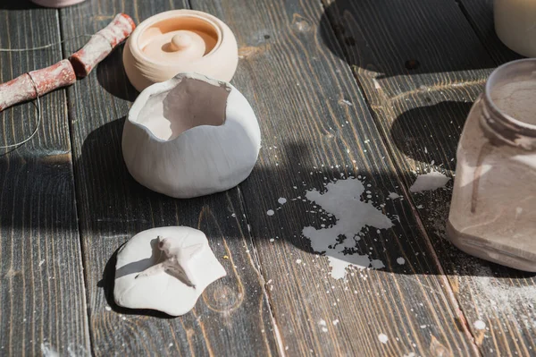 Arte de la cerámica. Naturaleza muerta de las herramientas de fabricación de cerámica, cepillos y diferentes jarrones y cuencos de cerámica en el estudio de arcilla — Foto de Stock