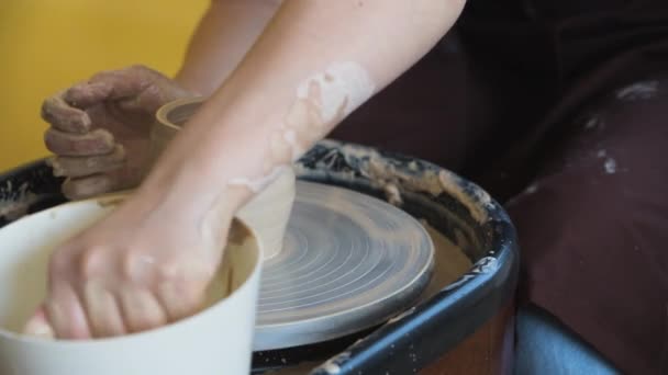 Female potter makes a pot on the pottery wheel close-up. — Stock Video