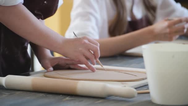 Женщины вручную делают глиняную керамику на столе с деревянным инструментом палки и деревянной скалкой . — стоковое видео