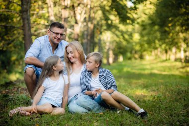 Mutlu bir aile yaz ormanında gülümsüyor.