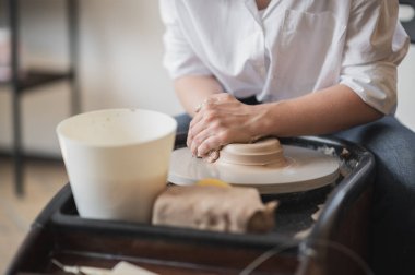 Dişi çömlekçi çömlek çarkında yakın plan bir demlik yapar..