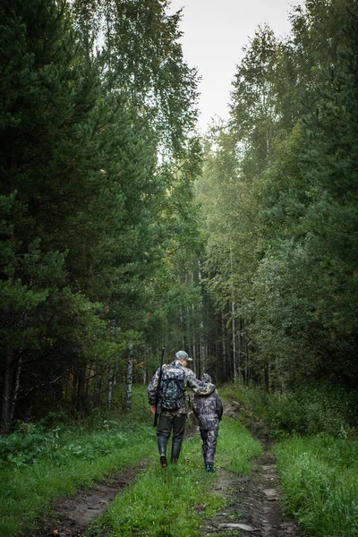 Vater und Sohn jagen gemeinsam. Auf der Straße nach der Vogeljagd. — Stockfoto
