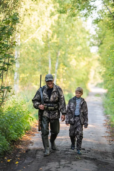 父子俩一起打猎猎鸟之后走在路上. — 图库照片