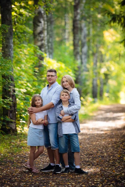 Happy family outdoors smiling in a summer forest — Stock Photo, Image