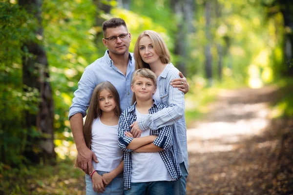 Gelukkig gezin buiten glimlachend in een zomerbos — Stockfoto