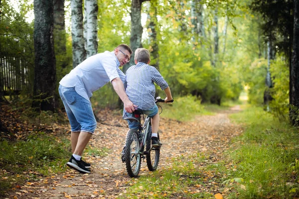 Father teaches son to ride the bicycle