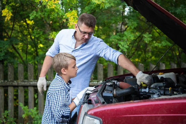 A father and son working together restoring an engine of their truck — Stock Photo, Image