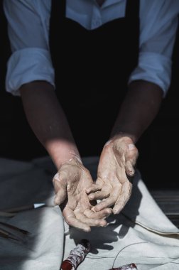 Ellerimi yıkamam lazım. Çömlek yaptıktan sonra kadın seramik sanatçısının kollarını kille kapatıyoruz..