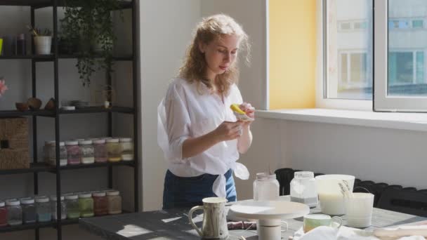 Γυναίκα αγγειοπλάστρια φτιάχνει κεραμικά πιάτα στο στούντιό της. Διαδικασία εργασίας κεραμικού δοχείου υαλοπινάκων. — Αρχείο Βίντεο