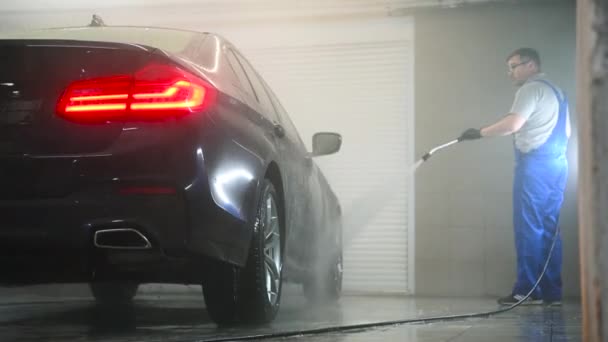 Trabajador de limpieza de automóviles con chorro de agua de alta presión en el lavado de coches. — Vídeos de Stock