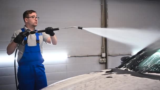 Arbetstagare vid Car Wash Shop, Använda tryck tvättmaskin på bilen, man tvätta bil med komprimeringsvatten. — Stockvideo