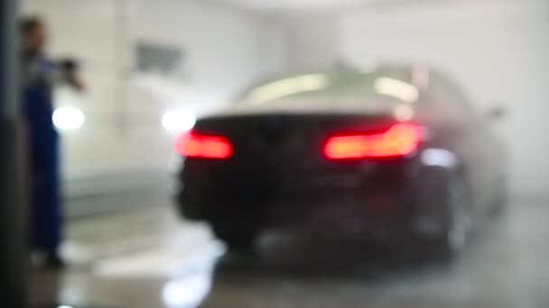Filmati sfocati sfocati di lavaggio con uno spruzzatore ad alta pressione presso il centro di cura auto per lo sfondo — Video Stock