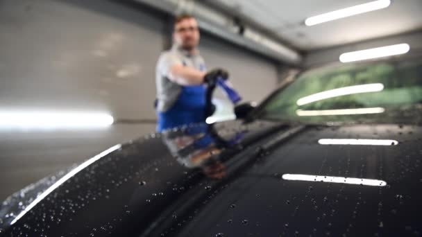 Fecho de movimento lento soprando água do carro preto recém-lavado com ar. Lavagem de carro e serviço de detalhamento. — Vídeo de Stock