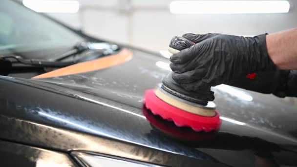 Les mains maîtresses polissent la vieille surface de la voiture via la mashine polie dans un atelier de voiture, gros plan au ralenti. — Video