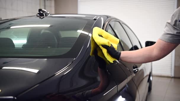 Master terminar de lavar el coche negro y limpiar el lado de un coche con tela en un taller de coches, cámara lenta . — Vídeos de Stock