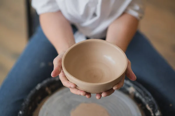 用金属丝剪断的产品。工匠手工制作陶器碗.在陶工轮上工作的女人。家族企业用土雕锅. — 图库照片
