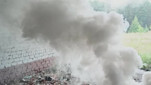 Homme militaire armé d'un fusil d'assaut traversant la fumée dans un bâtiment abandonné