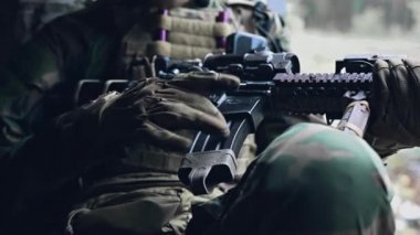 Bir yeri beklerken silah teftişi. Asker saldırı tüfeğini kontrol ediyor ve operasyona hazırlanıyor. Görüntüyü kapat