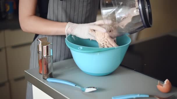 La mujer revuelve carne picada en un plato azul. Se muestra el proceso de mezcla manual. Primer plano — Vídeo de stock