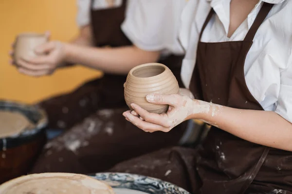 两个女孩在陶艺作坊做砂轮制作粘土手工工艺，友谊与指导理念 — 图库照片