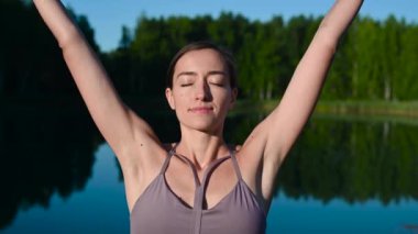 Sakin genç bir kadın derin bir nefes alıyor. Derin bir nefes alıyor. Meditasyon yapıyor, huzurun tadını çıkarıyor.