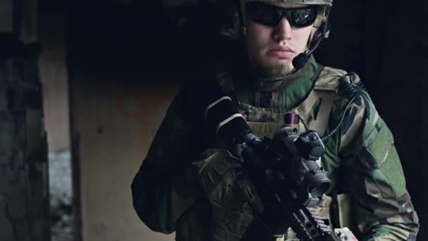 Оружие крупным планом на военнослужащего, стоящего в здании и ожидающего команды. — стоковое видео