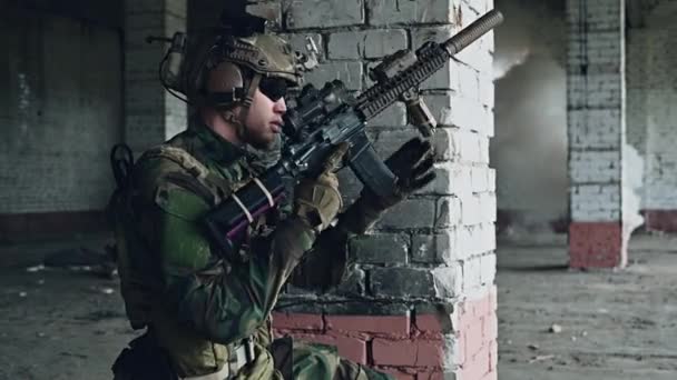 Солдат втягує боєкомплект у штурмову гвинтівку, переміщуючись у покинуту будівлю, щоб очистити територію під димом . — стокове відео