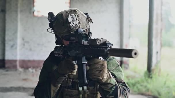 Stabiliserat skott av soldat i kamouflage siktar misshandel gevär och kör inuti byggnaden — Stockvideo