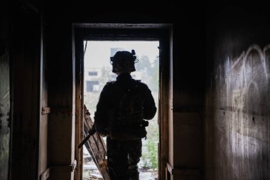 Ön cephede, elinde tüfekle beyaz bir asker var. Etrafı kolaçan ediyor..