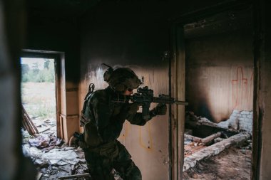 Terk edilmiş binaya giren tam donanımlı Amerikan askeri, MK18 saldırı tüfeğiyle farklı açıları hedefliyor.