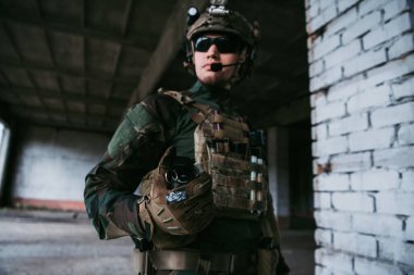 Çatışma sırasında binaya sis bombası atmaya hazır bir asker var..