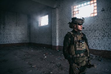 Ön cephede, elinde tüfekle beyaz bir asker var. Etrafı kolaçan ediyor..