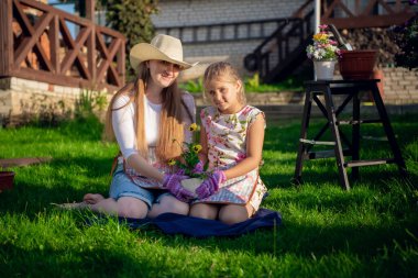 Bahçıvanlık, çiftçilik, anne-kız çiçek saksısına çiçek ekme.