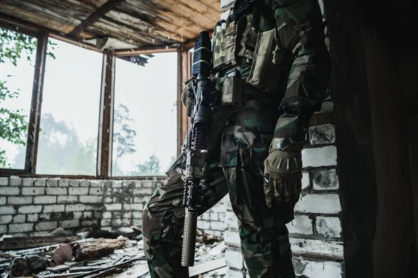 건물 안에 서서 명령을 기다리는 한 군인에게 총구를 겨누고 있습니다.. — 스톡 사진