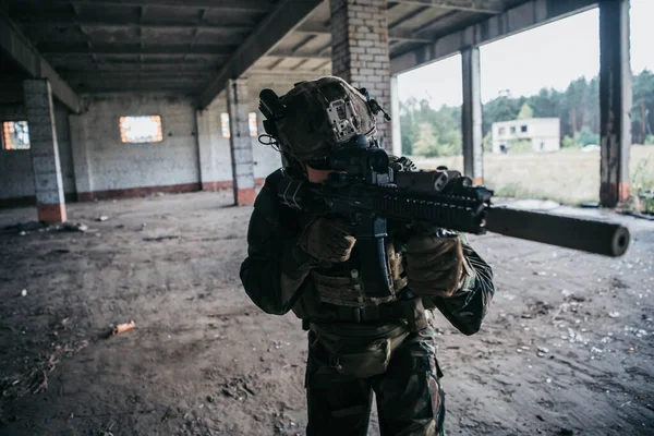 Żołnierz w pełnym wyposażeniu US MARSOC wchodzący do opuszczonego budynku, celujący pod różnymi kątami ze strzelby szturmowej MK18 — Zdjęcie stockowe