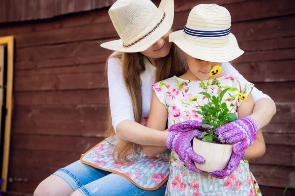 Jardinage, plantation - mère avec sa fille plantant des fleurs dans le pot de fleurs — Photo