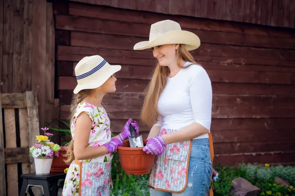 Femme et fille, mère et fille, jardinage ensemble plantation de fleurs dans le jardin. — Photo