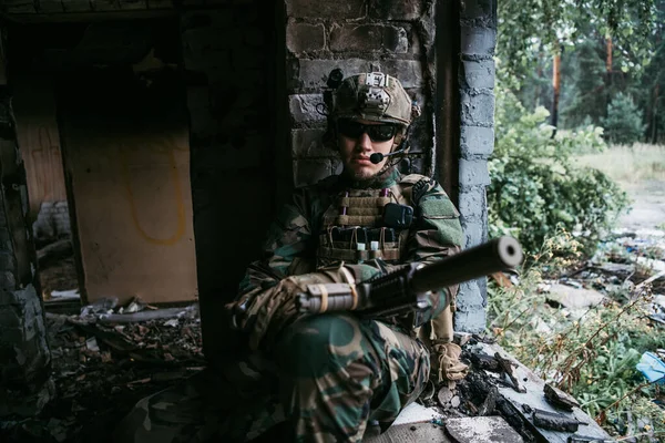 Gros plan d'un soldat professionnel entièrement équipé regardant la caméra. — Photo