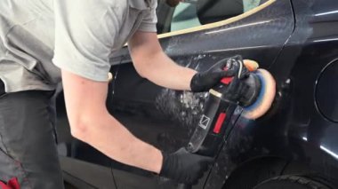 Araba tamiri, oto tamirhanesinde orbital parlatıcıyla el işi. Seçici odak.