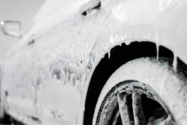 Proceso de lavado de autos. Detergente espumoso cubre el lado del coche, limpiarlo de la suciedad y el polvo. — Foto de Stock