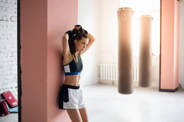 Během tréninku si pěkná kickboxerka dala pauzu na odpočinek a opřela se o zeď — Stock fotografie
