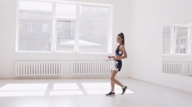 Koridorda iple antrenman yapan genç bir kız.